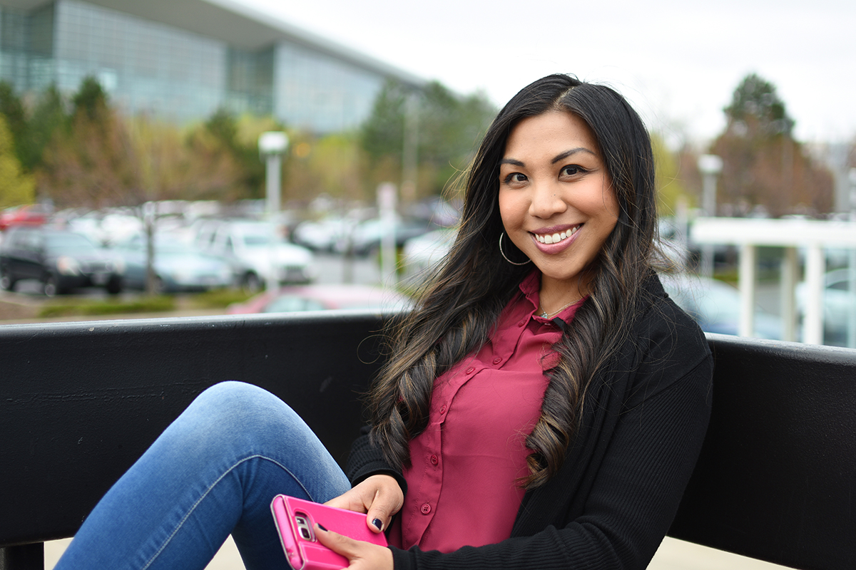 Young woman sitting holding a cell phone