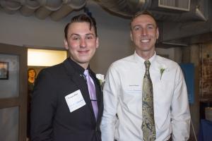 two men stand next to each other for photo