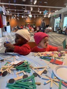 Two children one in red and the other in pink making ornaments