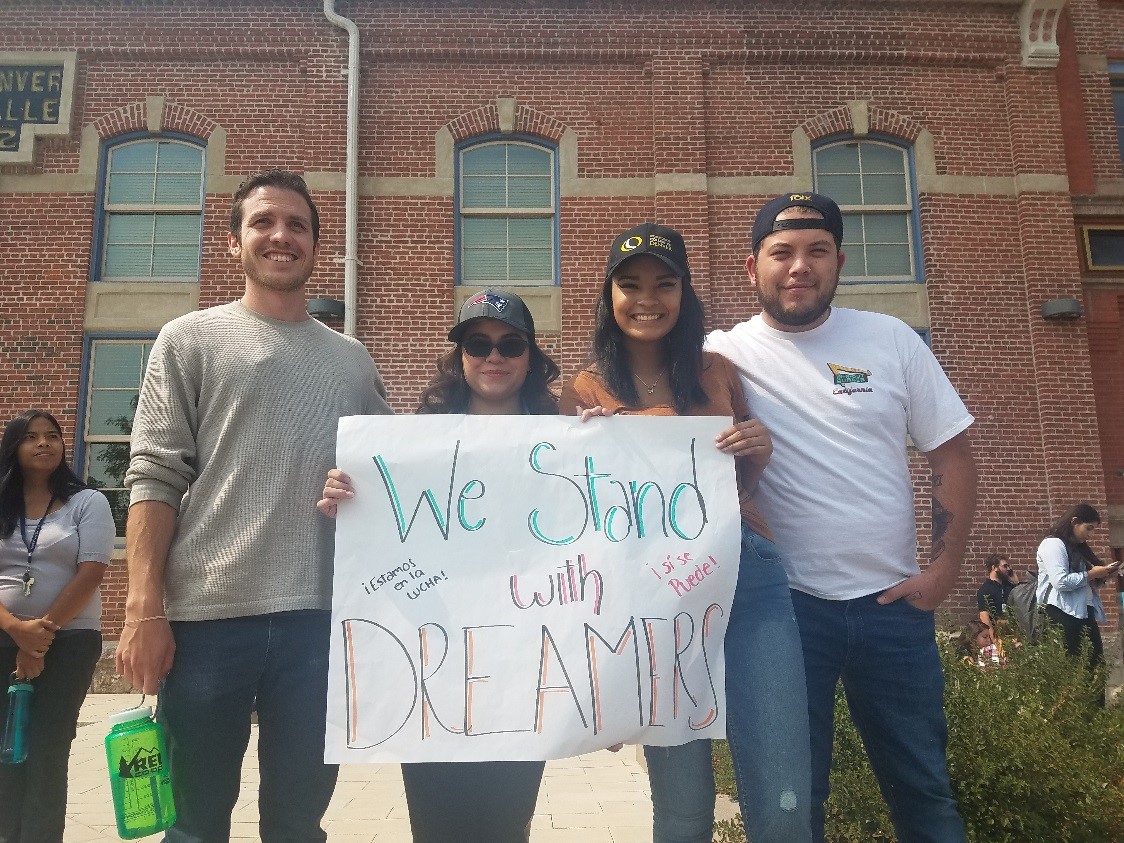 students holding a sign at a rally on the Auraria Campus