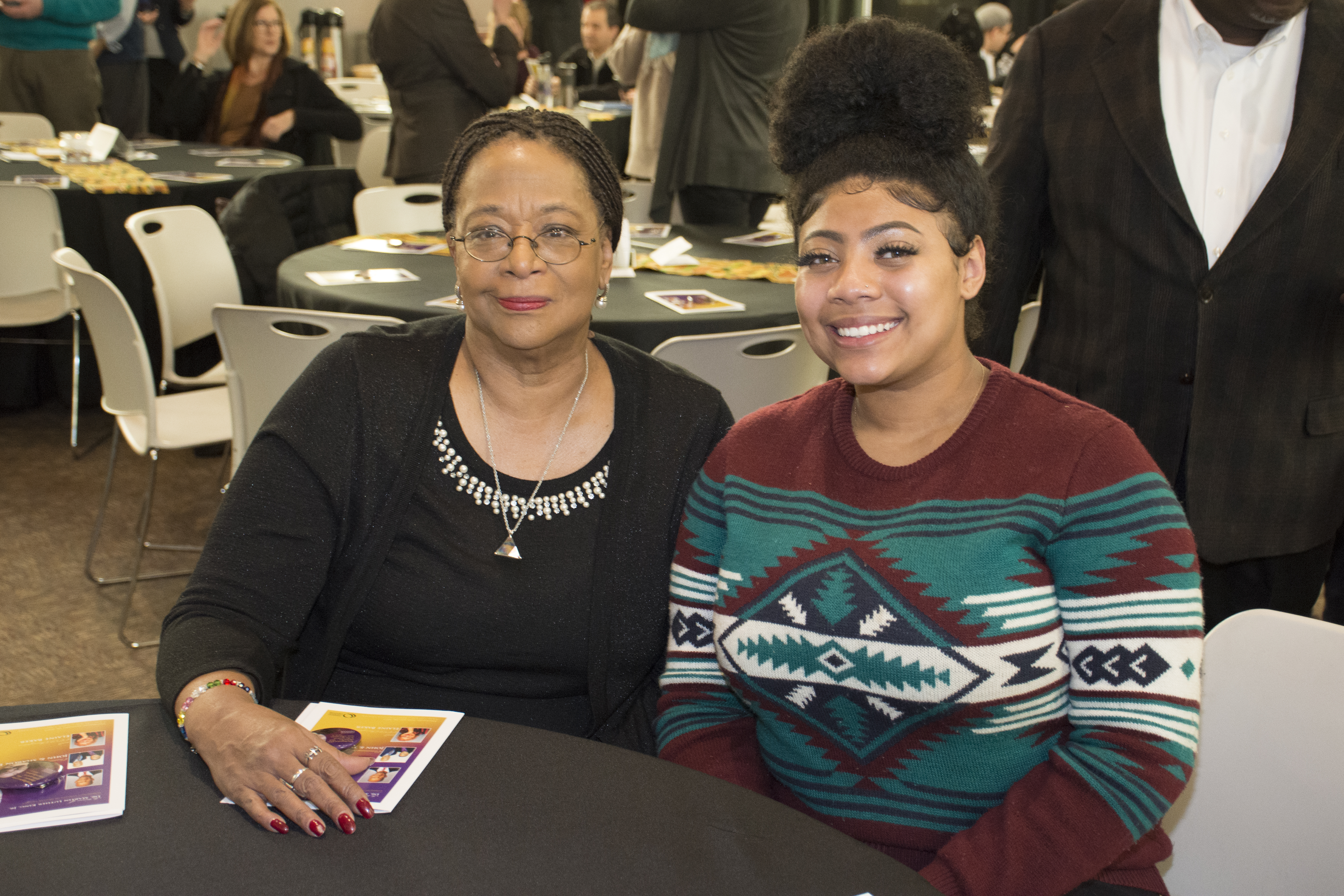 two females sitting at a table at an awards ceremony