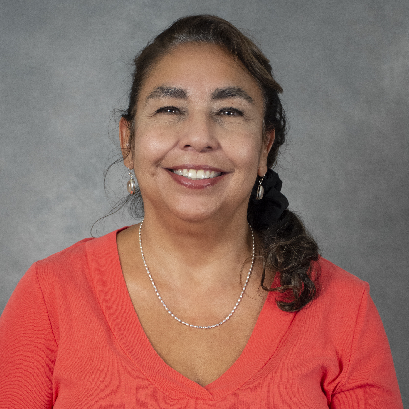 Smiling woman in a coral colored shirt