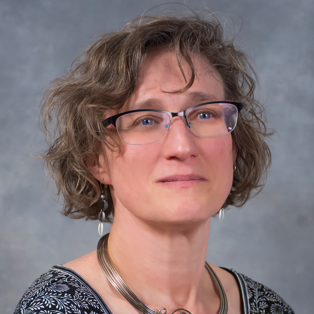 Person wearing glasses and a black floral shirt.