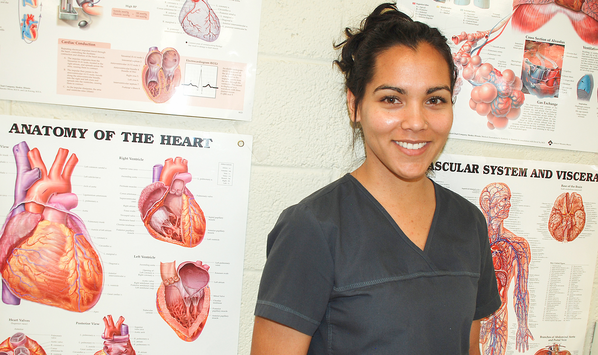 nursing student in front of human anatomy posters