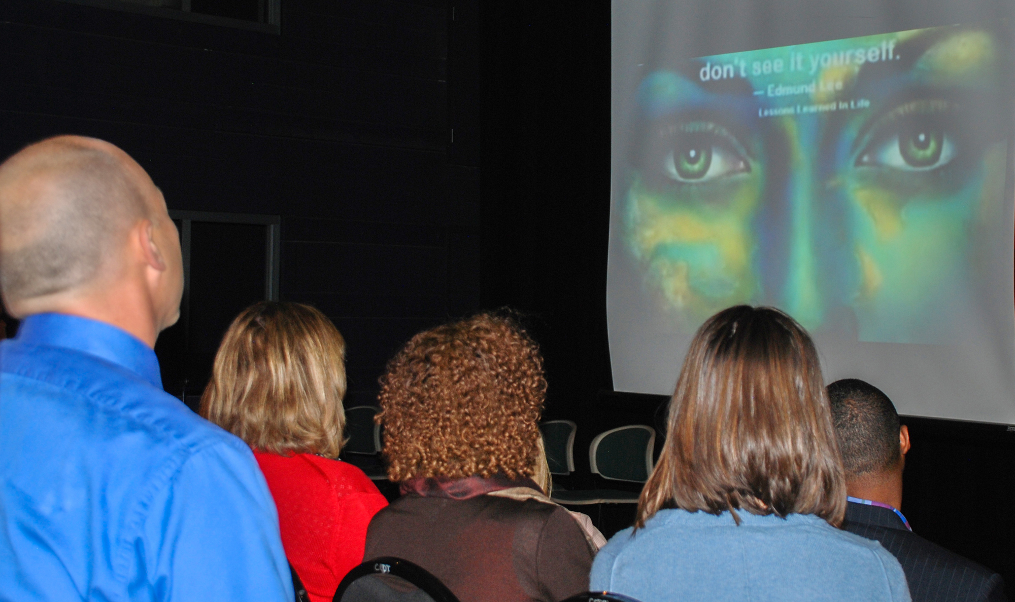 Faculty and students watch Digital Stories at the Film Fest. group of people in a theater watching a film