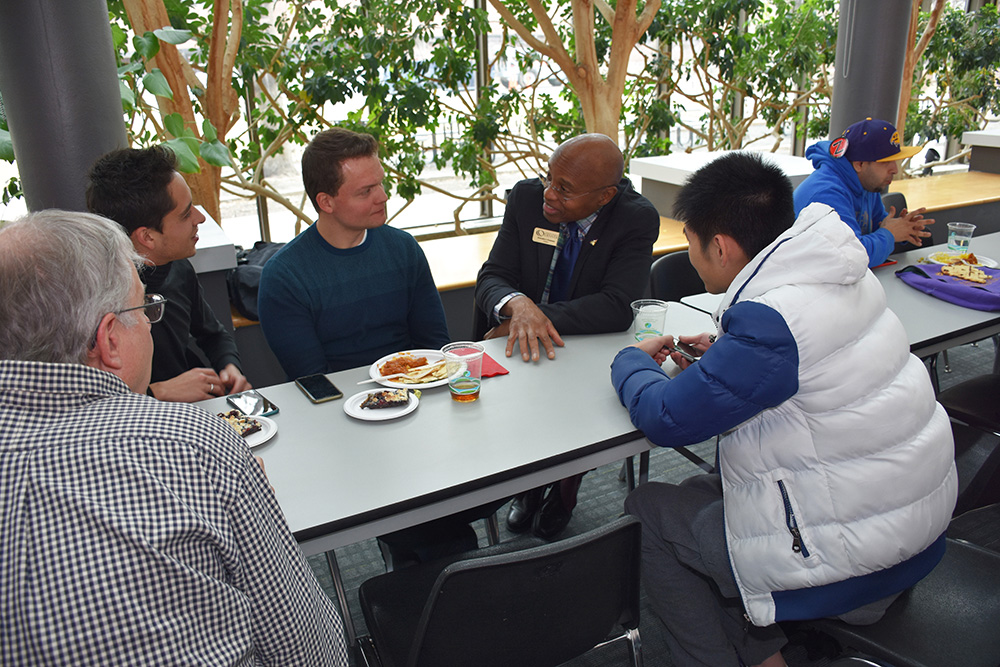 Everette talking to students at a table