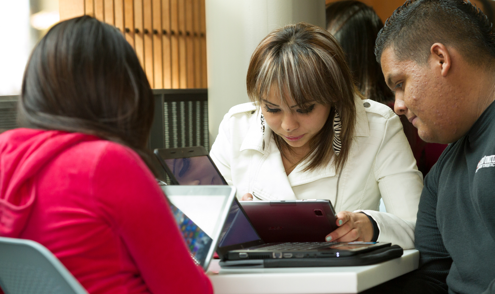 three students work together on computers