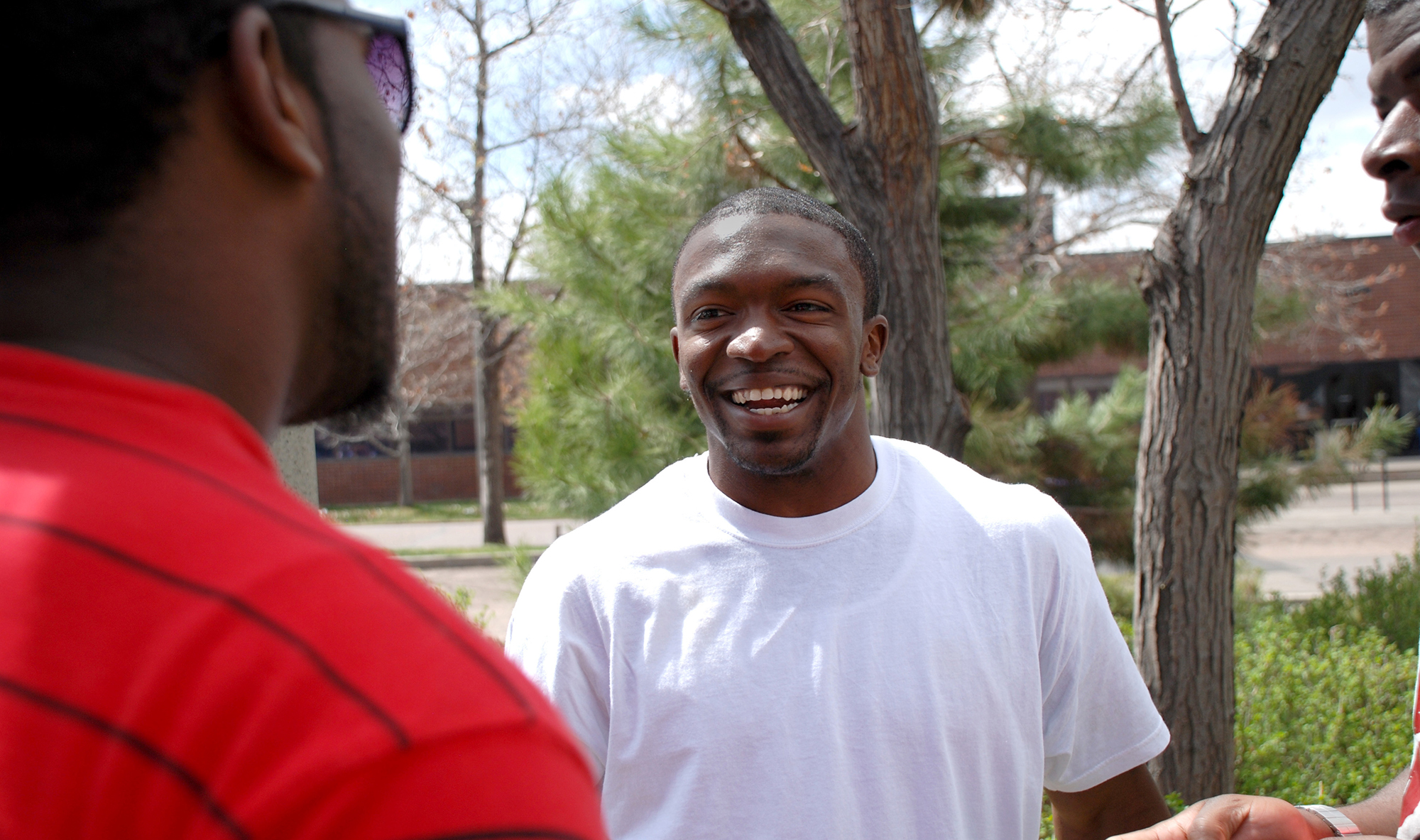 Three male CCD students laughing in the Cherry Creek Courtyard