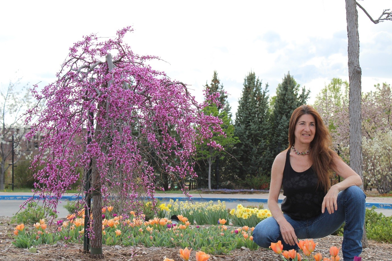 woman sitting outside next to Cherry Blossom tree