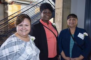 three women smile for camera