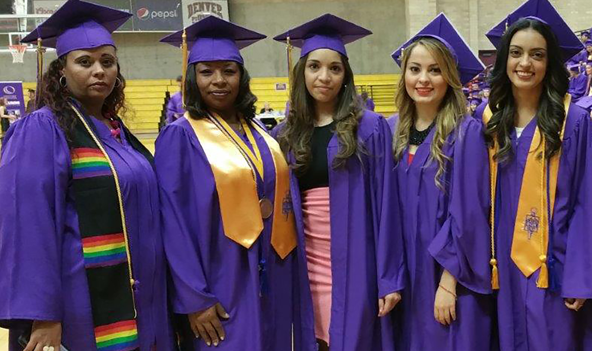 five women in purple cap and gown graduation regalia