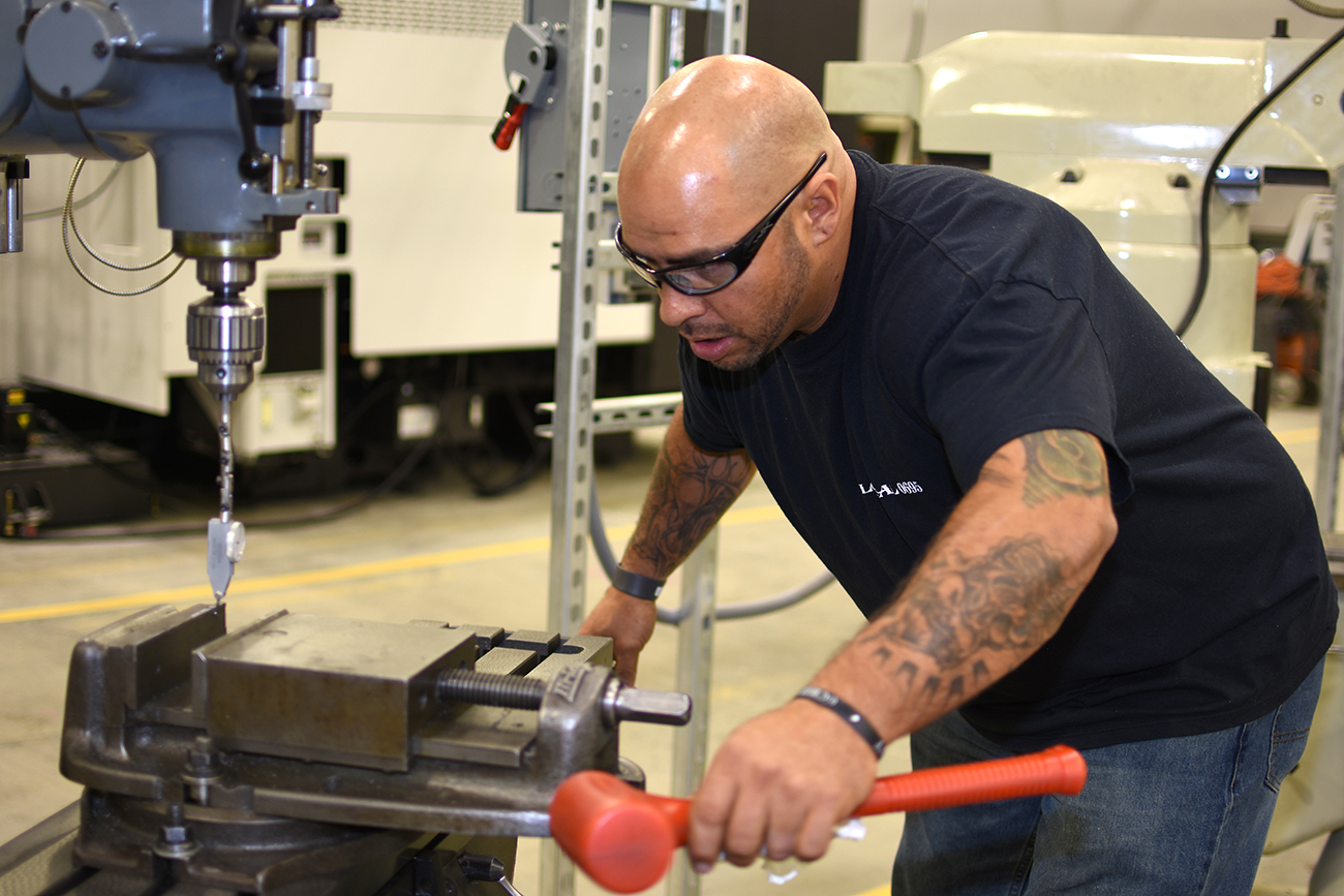 man in protective glasses learns to operate a machine