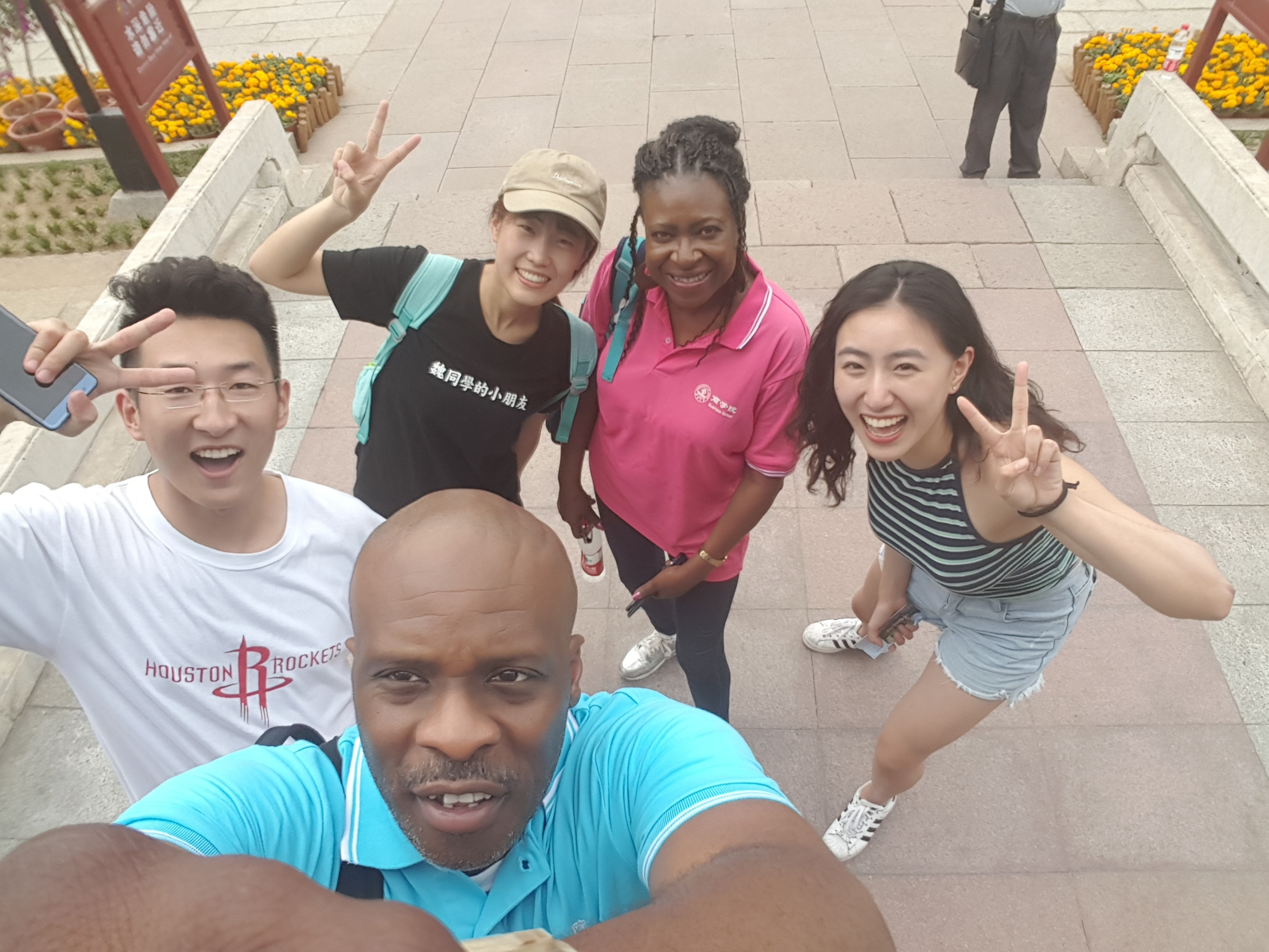 an instructor and her husband taking a selfie with three students in China