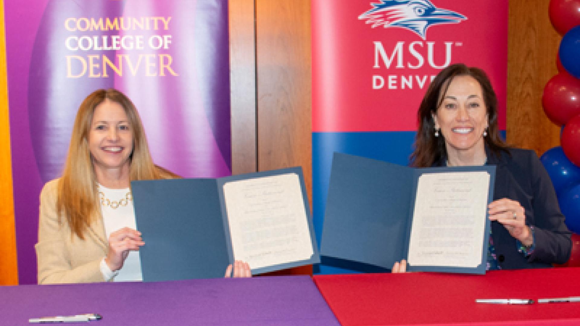 Dr. Marilena DeSanctis and Dr. Janine Davidson holding up signed documents.