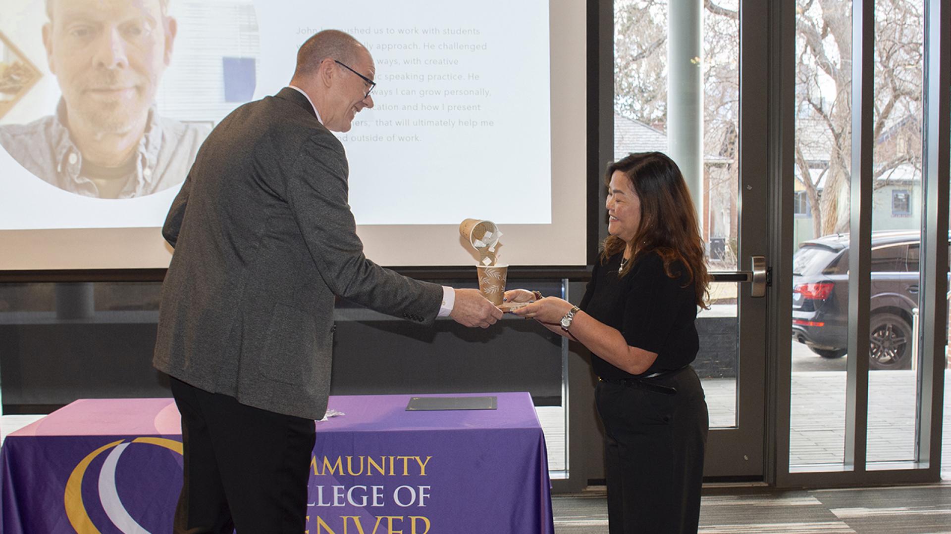 Interim President of CCD handing award to team member 