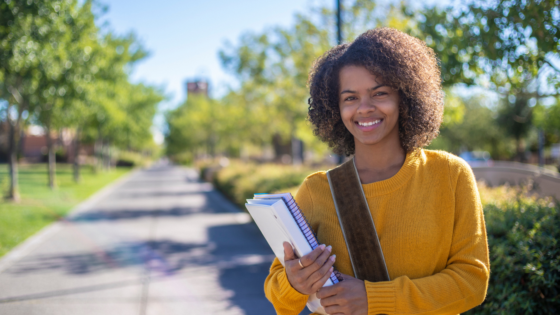 Women of color in a yellow shirt, at the park standing outside