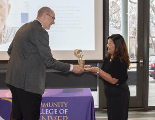 Interim President of CCD handing award to team member 