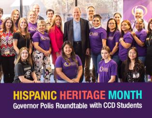 Governor Jared Polis, President DeSanctis, and students posing for a photo.