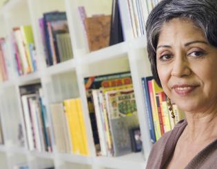 image of mature female student in front of bookshelf full of books