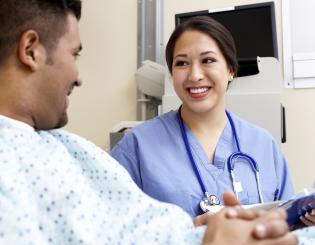 Young nurse sitting with a male patient.