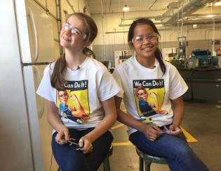 two girls sitting together smiling