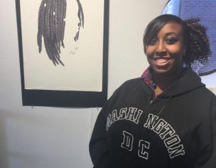 young black woman standing with a drawing smiling