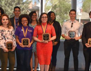group of well dressed students holding their awards