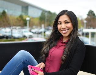 Young woman sitting holding a cell phone