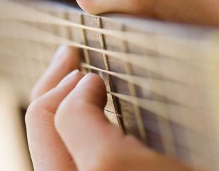 fingers strumming a guitar