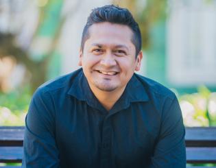 man wearing black button down sitting on a bench