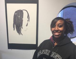 young black woman standing with a drawing smiling