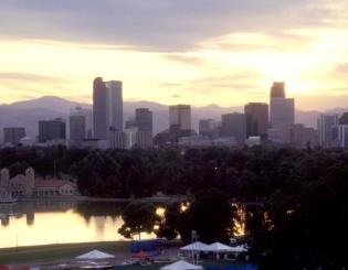 Downtown Denver and mountains from City Park at dusk