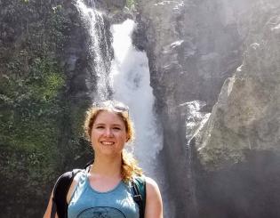 young woman in front of a waterfall