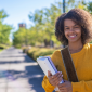 Women of color in a yellow shirt, at the park standing outside