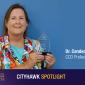 Image of Dr Candace Ruiz accepting an award with a blue background 