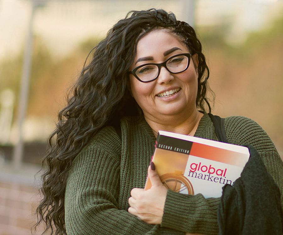 Woman wearing green sweater holding coursebook