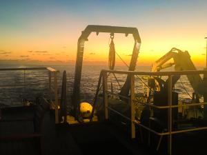 Image of the Nautilus Exploration Vessel in open Pacific Ocean off Mexico with sunset in background.