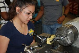 female works on machining equipment
