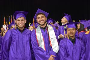 three male grads at commencement in cap and gown