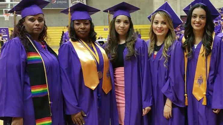 five women in purple cap and gown graduation regalia
