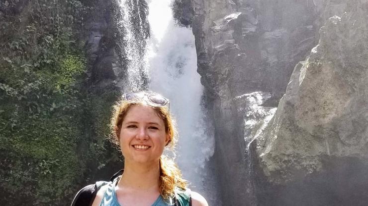 young woman in front of a waterfall