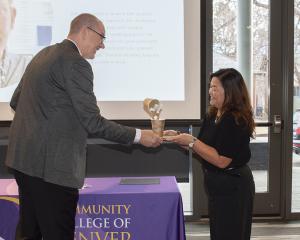 Interim President of CCD handing award to team member 
