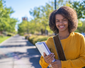 Women of color in a yellow shirt, at the park standing outside