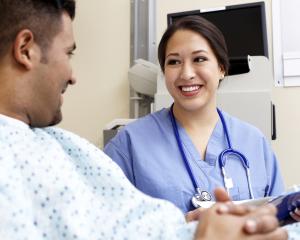 Young nurse sitting with a male patient.