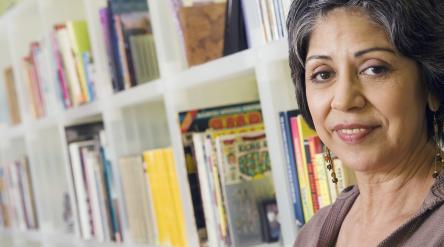 image of mature female student in front of bookshelf full of books