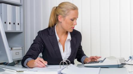 Female accountant using an adding machine