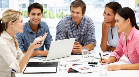 image of a group of five adults looking at graphs and talking