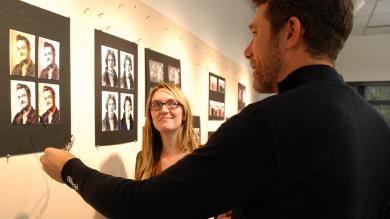 man and woman discuss the graphic image on the wall created by graphic designer