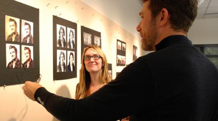 man and woman discuss the graphic image on the wall created by graphic designer