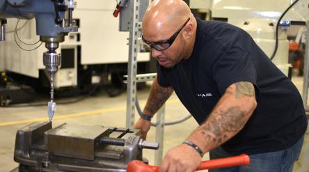 man in protective glasses learns to operate a machine